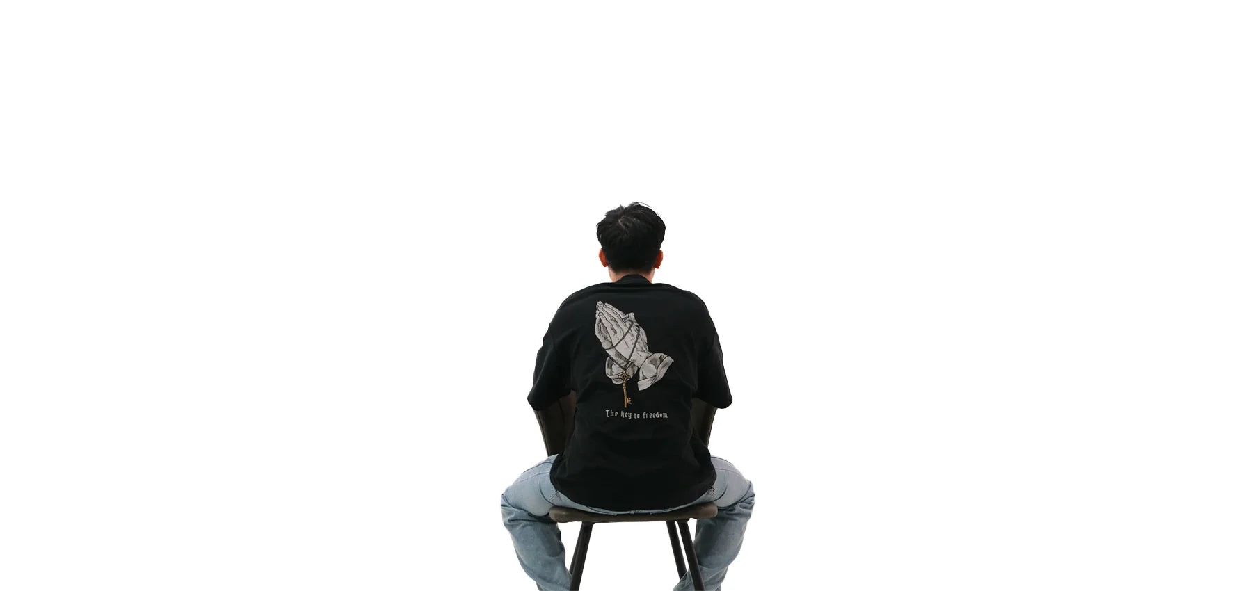 Back view of oversized black NO1 Apparels anime t-shirt, subtle anime streetwear inspired by Attack on Titan Key to Freedom design with basement key motif worn by male model.