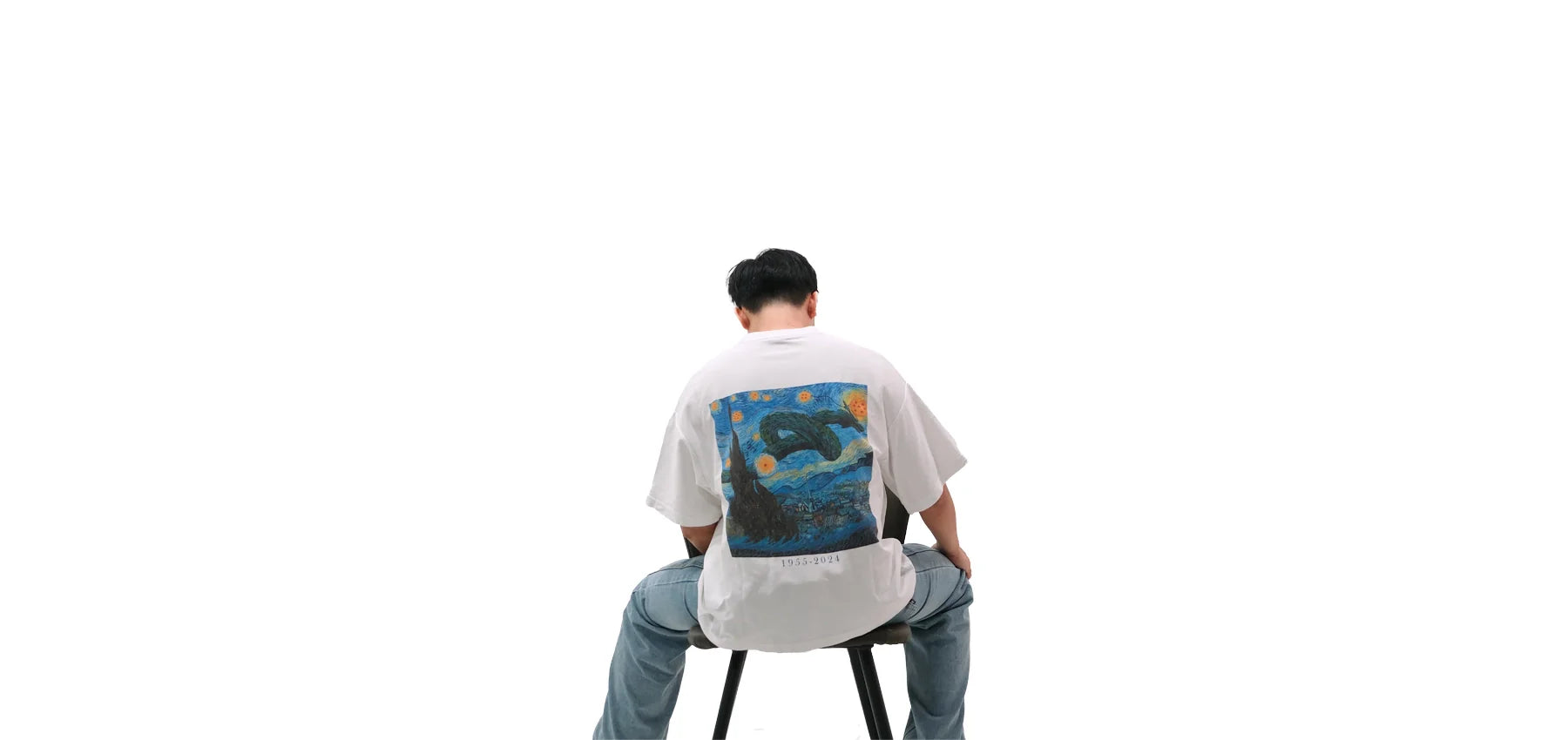 Back view of oversized white NO1 Apparels anime t-shirt, subtle anime streetwear featuring Van Gogh starry sky with Dragon Ball dragon and seven dragon balls, worn by a seated male model.