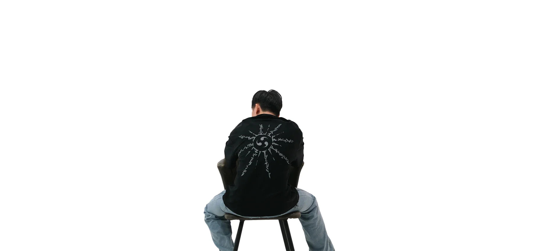 Back view of oversized black NO1 Apparels anime t-shirt, subtle anime clothing featuring Naruto inspired Cursed Mark motif, worn by a seated male model.