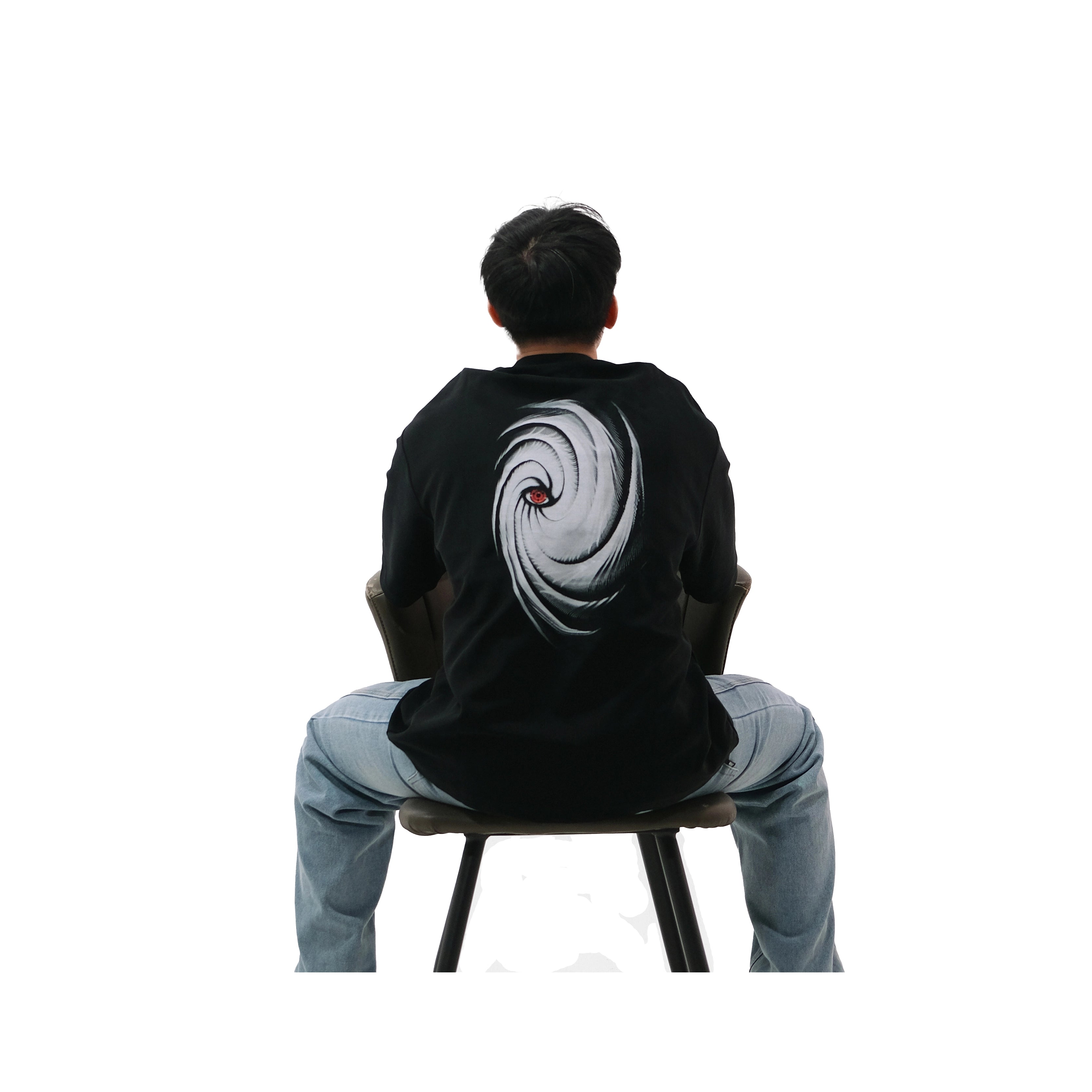 Back view of oversized black NO1 Apparels anime t-shirt, subtle anime clothing with Obito mask graphic inspired by Naruto, worn by male model sitting on chair.