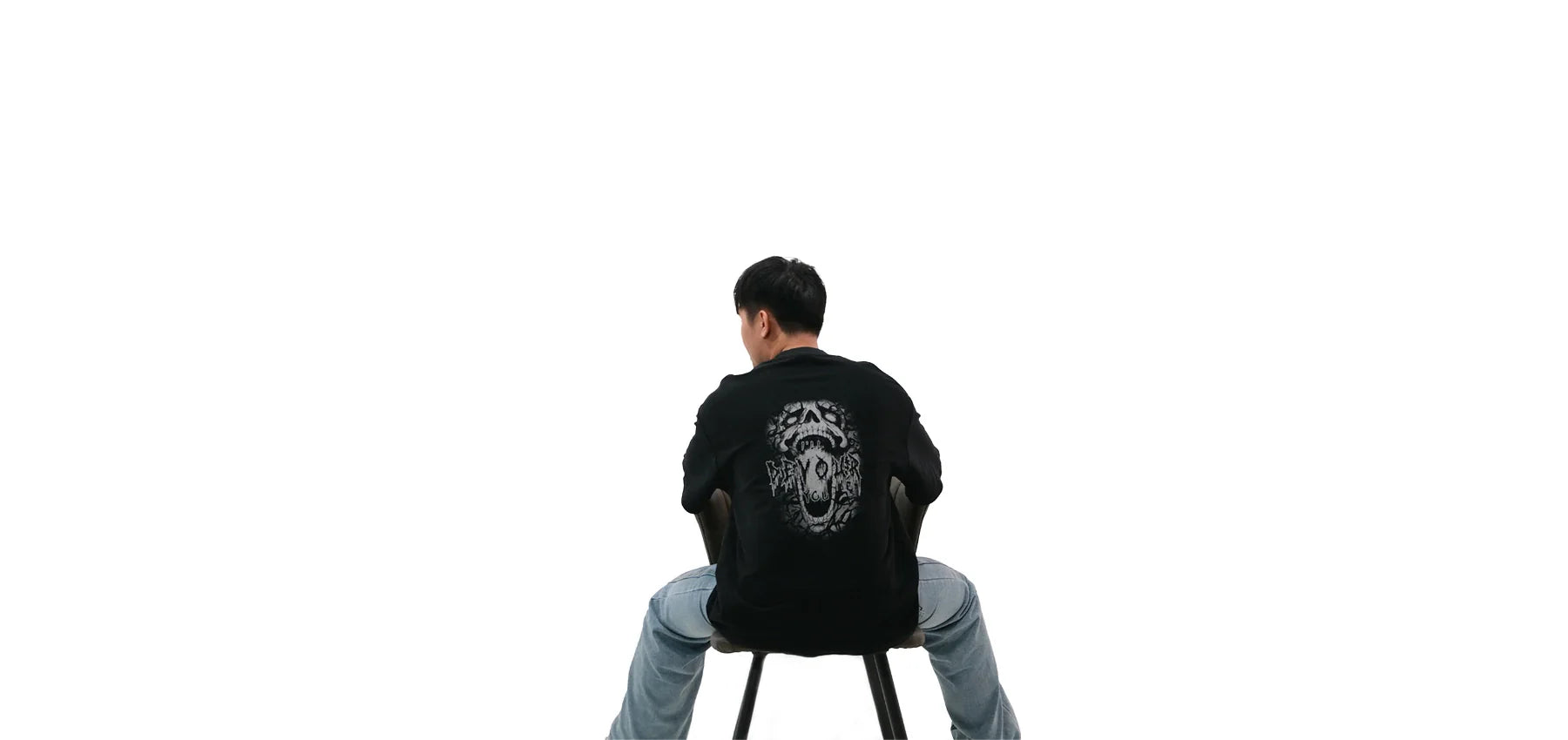 Back view of oversized black NO1 Apparels anime t-shirt, subtle anime clothing inspired by Blue Lock featuring Nagi Seishiro “I Will Devour You” graphic design, worn by a seated male model.