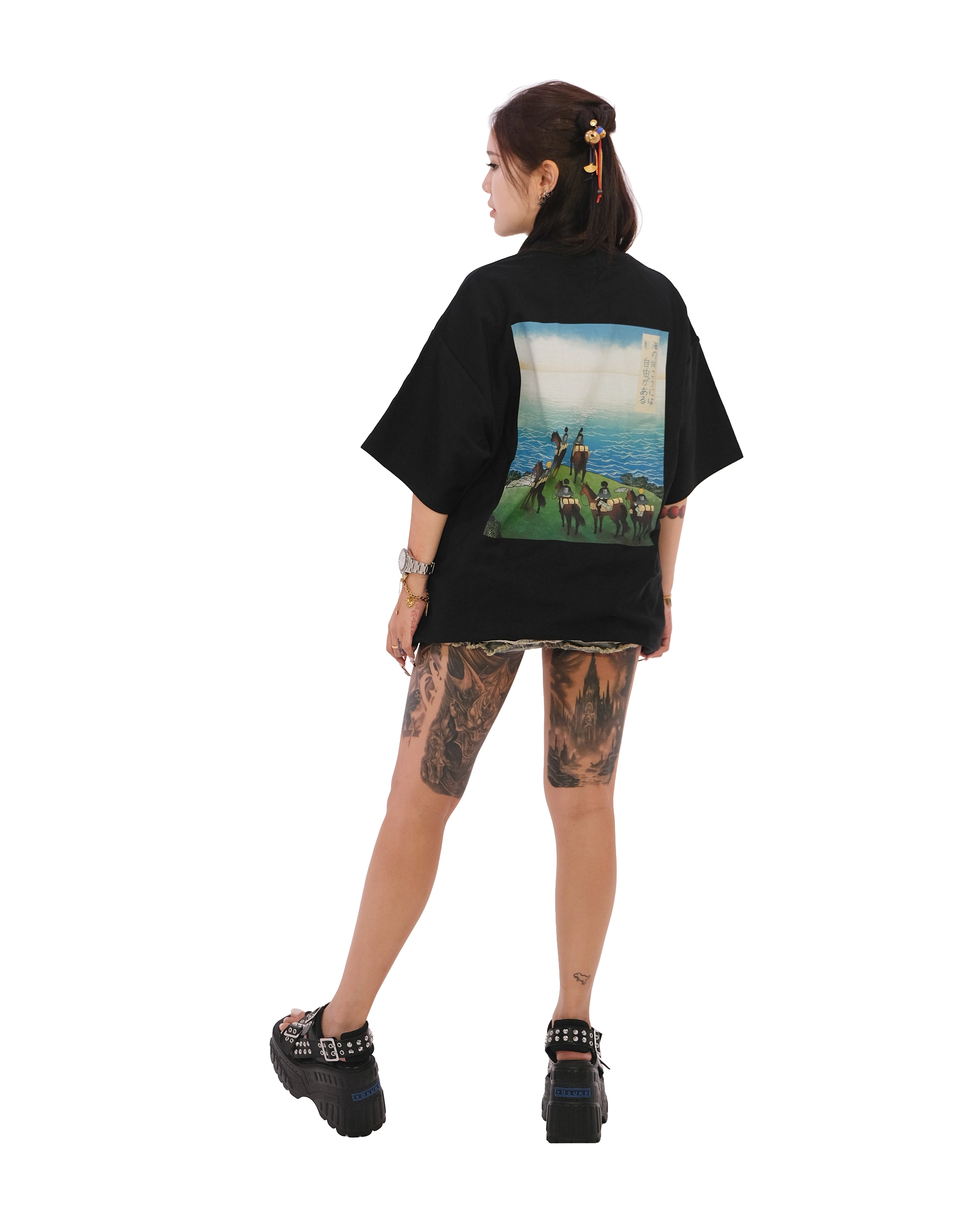 Back view of oversized black NO1 Apparels anime t-shirt, subtle anime clothing inspired by Attack on Titan, On The Other Side design featuring minimalist graphic inspired by the Scouts’ first view of the ocean, worn by female model.