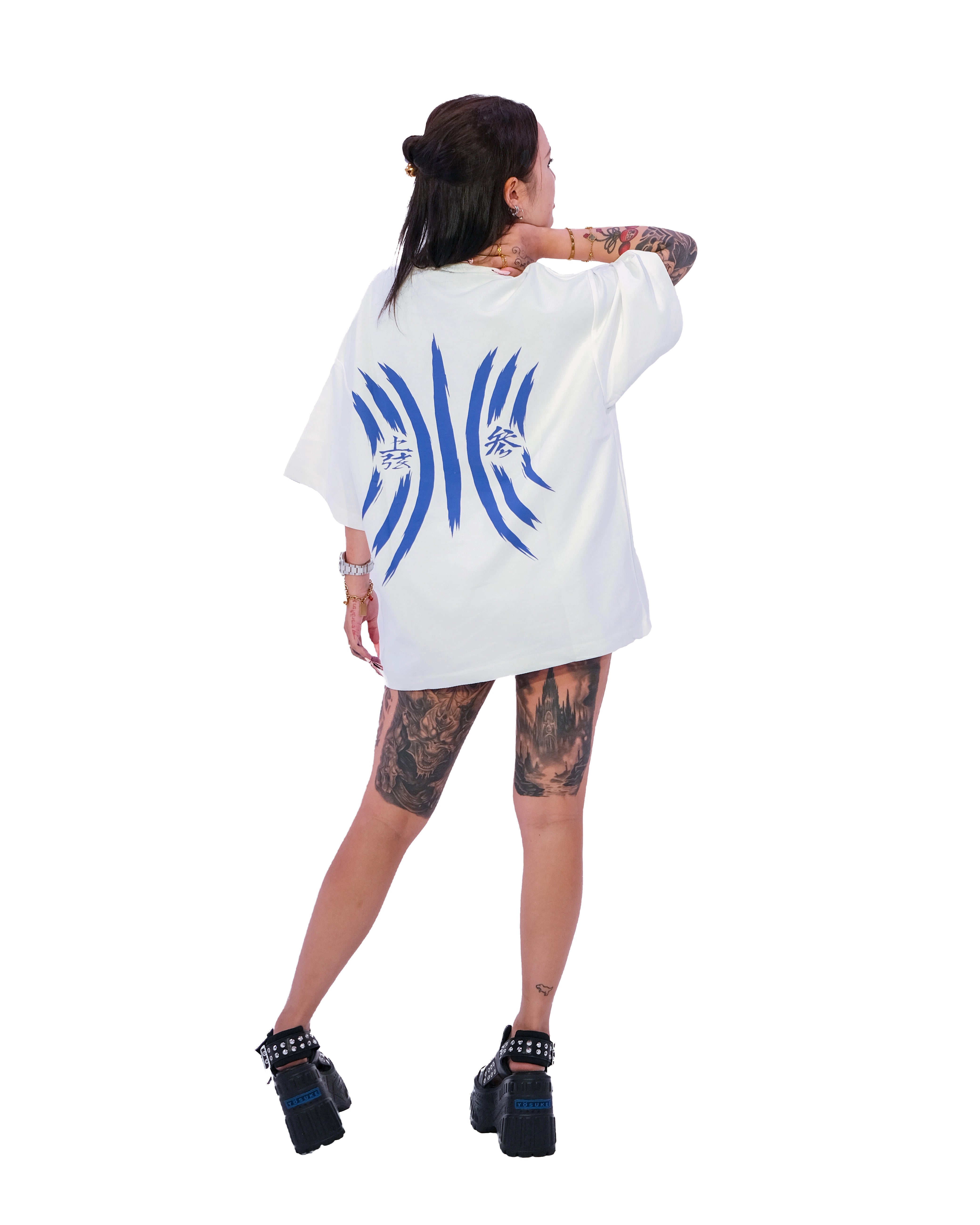 Back view of oversized white NO1 Apparels anime t-shirt, subtle anime clothing inspired by Demon Slayer, Akaza design featuring Akaza Tattoo Motif, worn by female model.