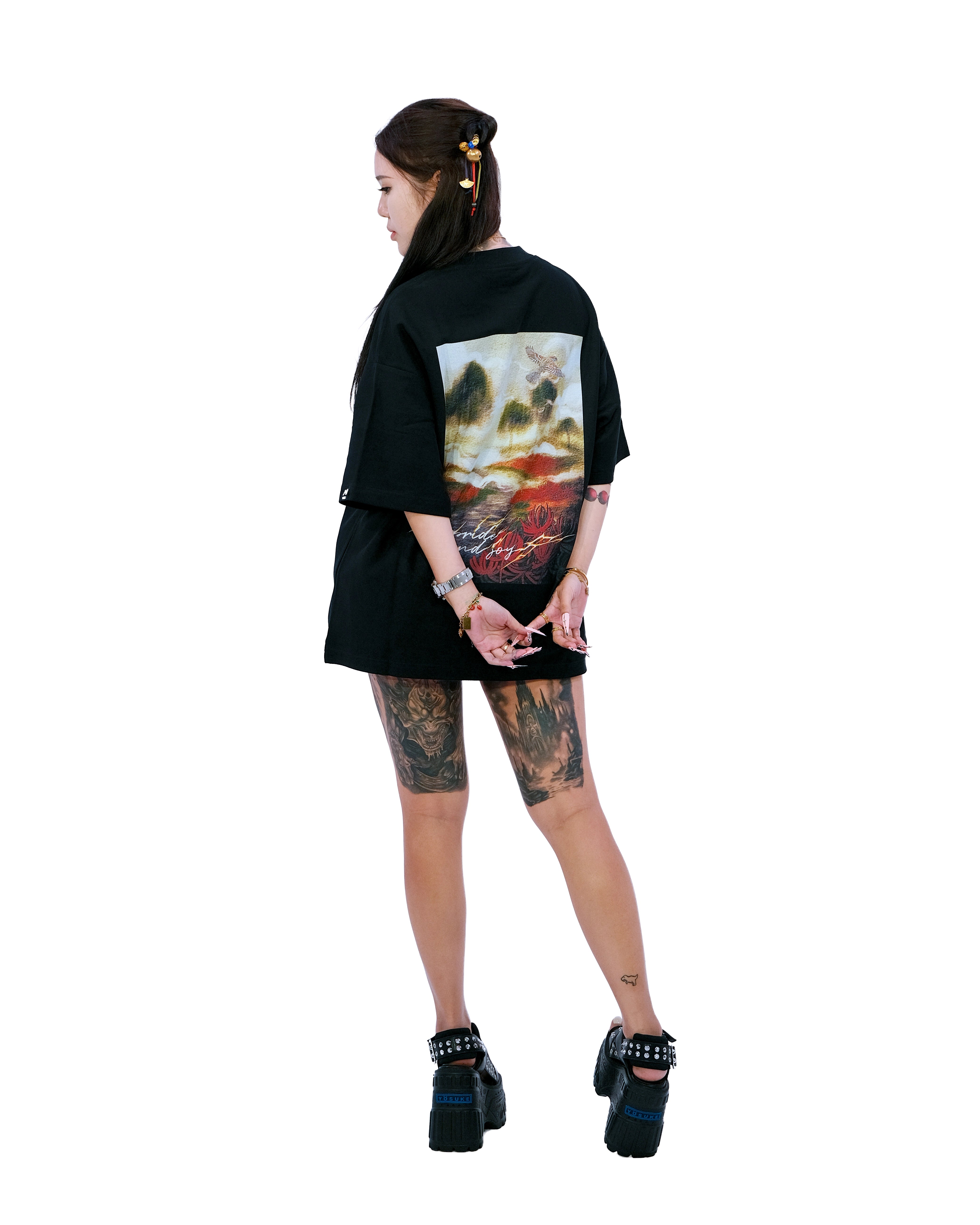 Back view of oversized black NO1 Apparels anime t-shirt, subtle anime clothing inspired by Demon Slayer, My Pride and Joy, Zenitsu design featuring a flower field, worn by female model.