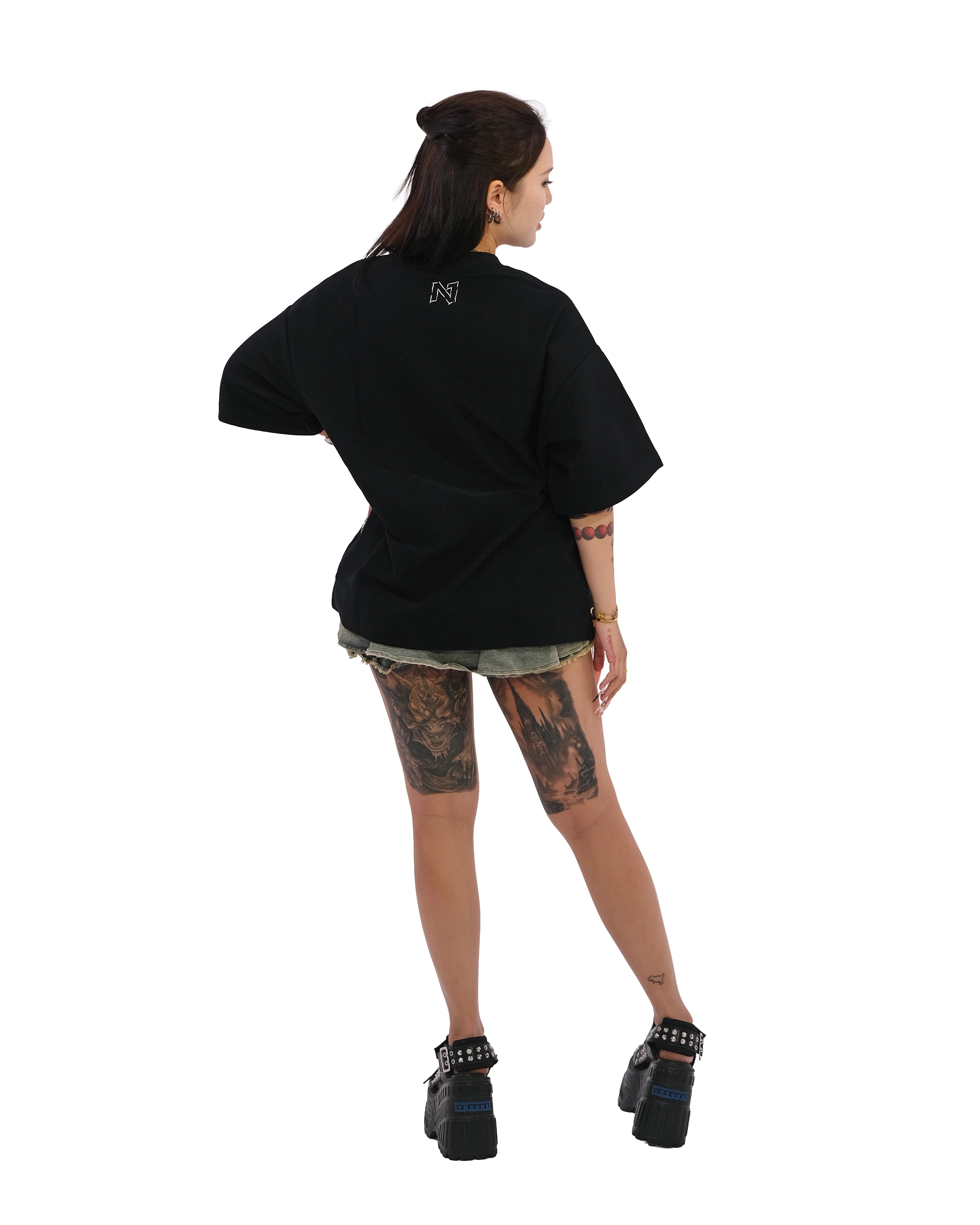 Back view of oversized black NO1 Apparels anime t-shirt, subtle anime clothing inspired by One Piece, Enemies of the Gods design featuring NO1 Logo, worn by female model.