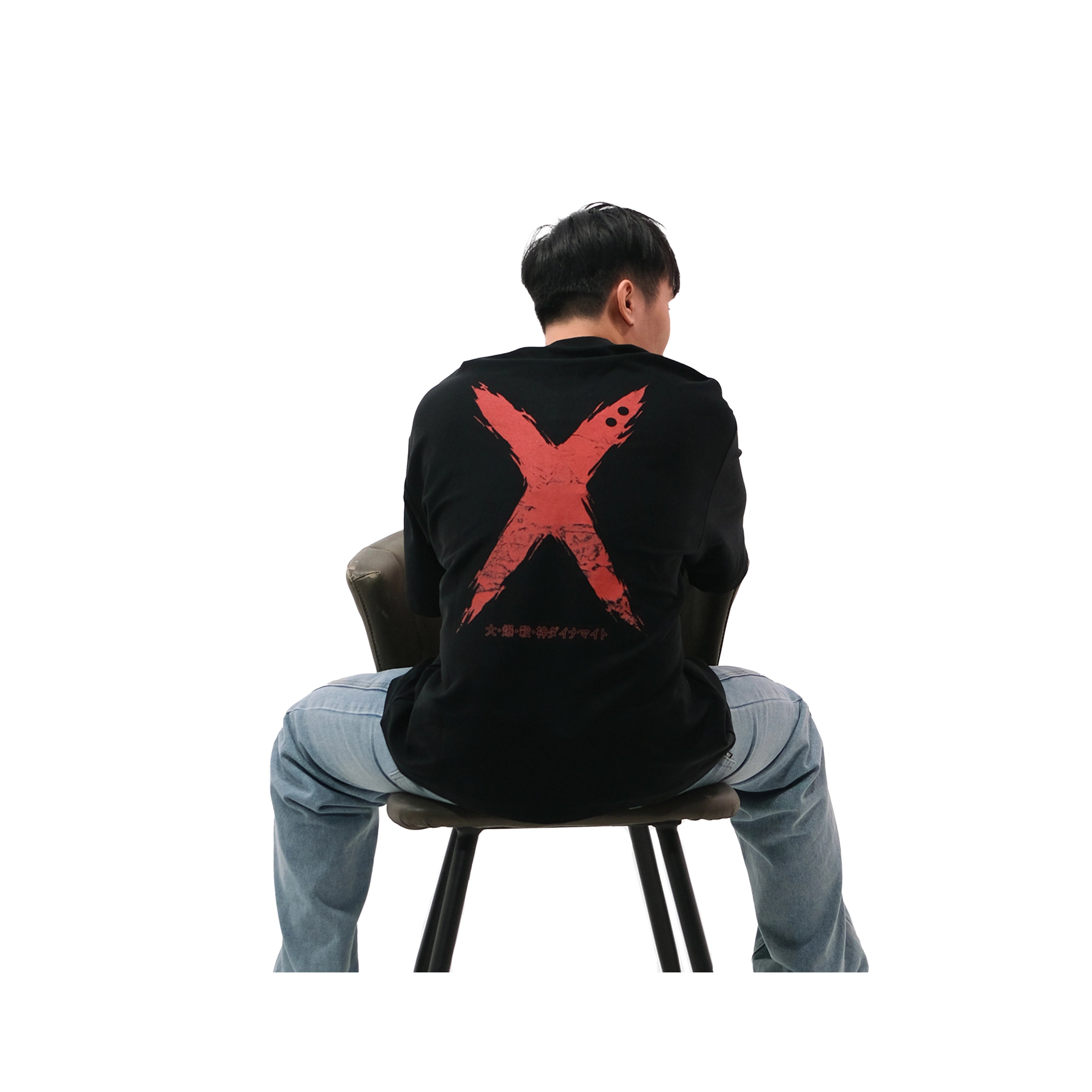 Back view of oversized black NO1 Apparels anime t-shirt, subtle anime streetwear inspired by My Hero Academia, Bakugo design with red X motif, worn by male model sitting on chair.