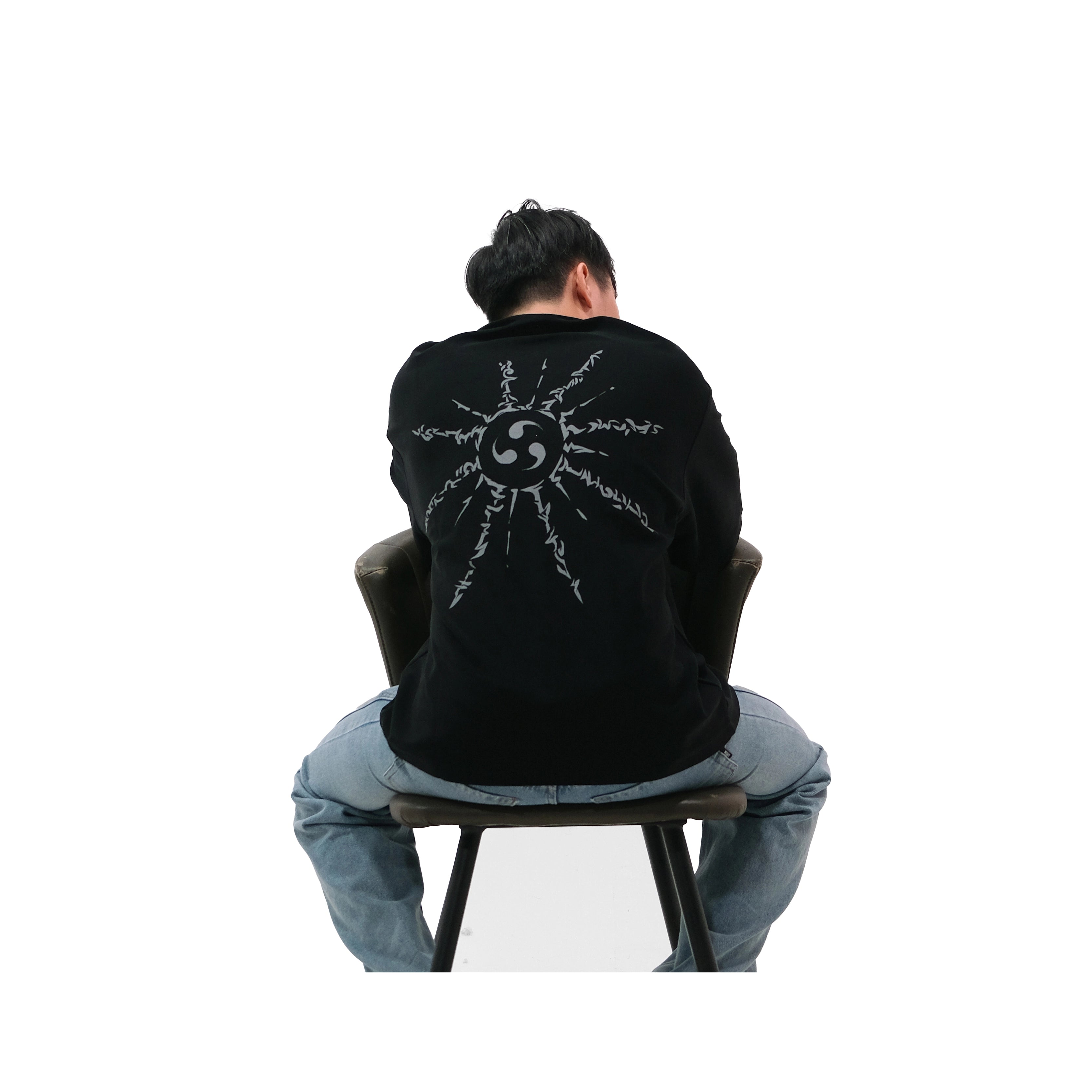 Back view of oversized black NO1 Apparels anime t-shirt, subtle anime clothing featuring Naruto inspired Cursed Mark motif, worn by a seated male model.