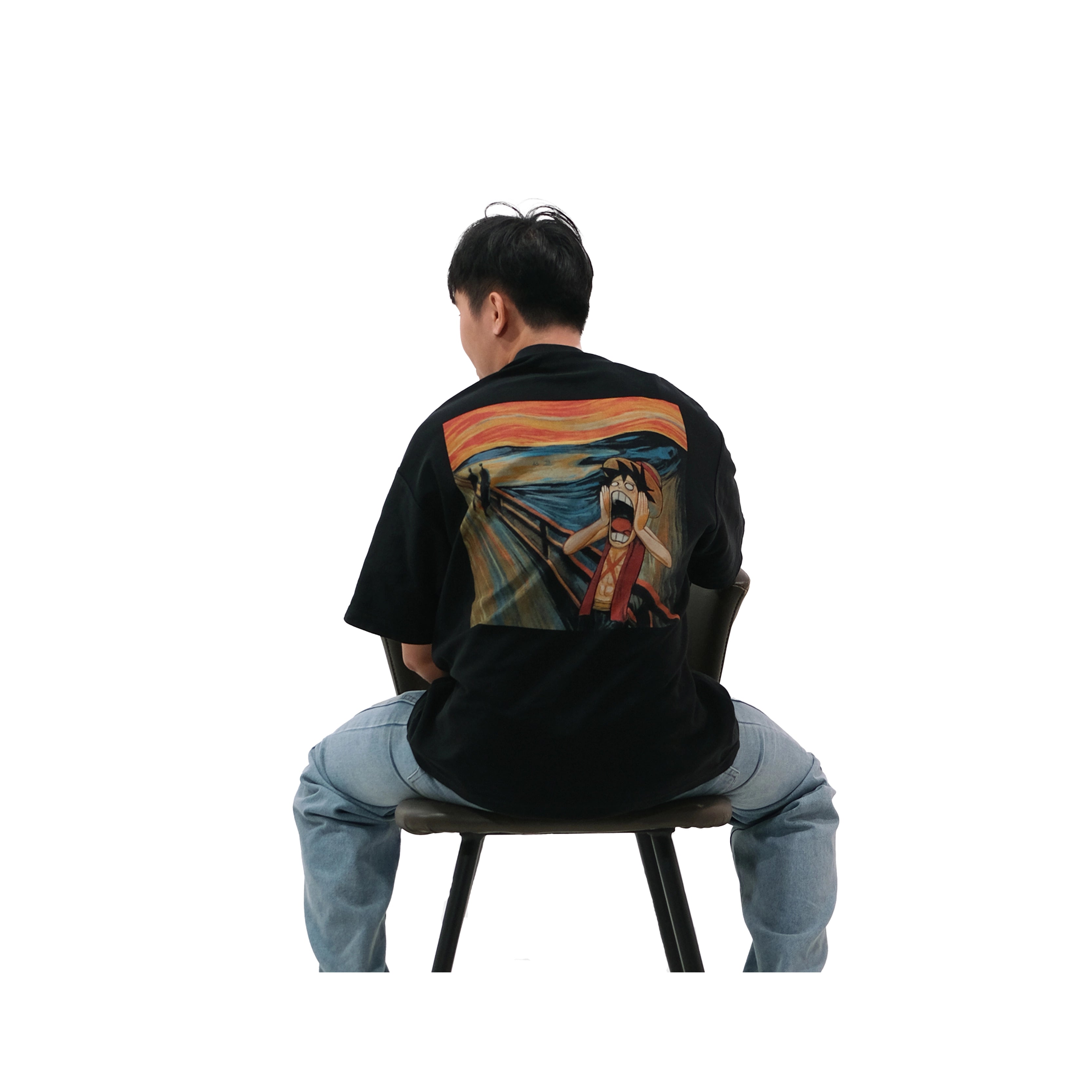 Back view of oversized black NO1 Apparels anime t-shirt, subtle anime streetwear inspired by One Piece Pirate’s Scream design reimagining The Scream painting, worn by male model sitting on chair.